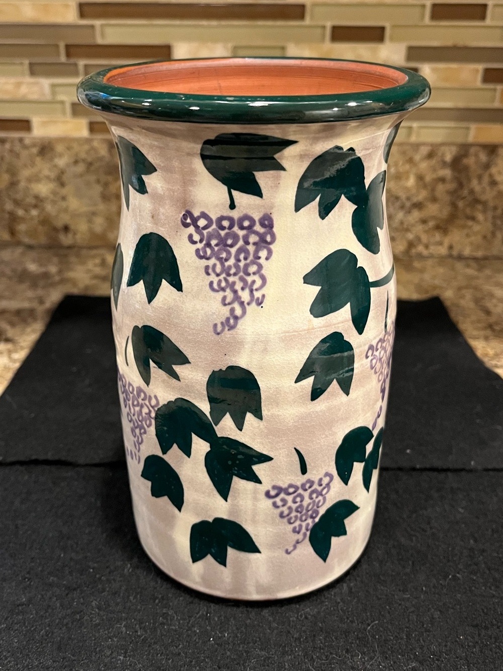 Handmade pottery vase cream-colored with a green and purple grape vine motif